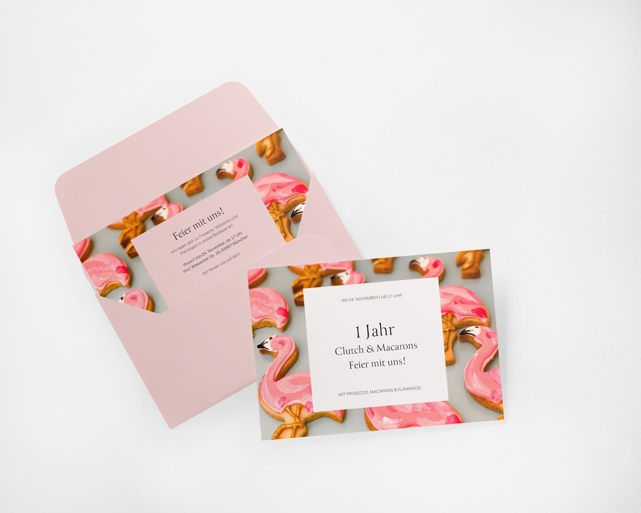 Einladung zum 1-jährigen Jubiläum von Clutch & Macarons mit rosa Flamingo-Keksen, feierlicher Atmosphäre und elegantem Design.